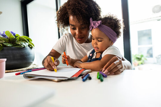 Mother and child coloring together at home