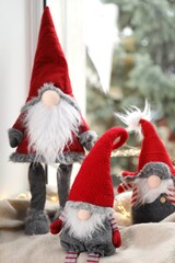 Christmas gnomes on blanket near window at home, closeup