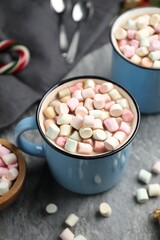 Tasty cocoa with marshmallows and Christmas decor on grey table, closeup