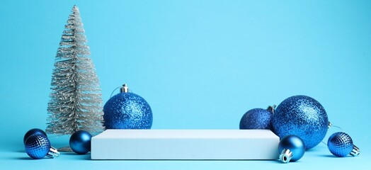 Empty podium and Christmas decor on light blue background, closeup. Space for text