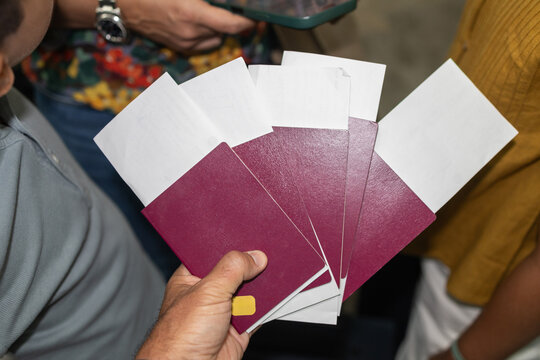Group holding passports and travel tickets in hand