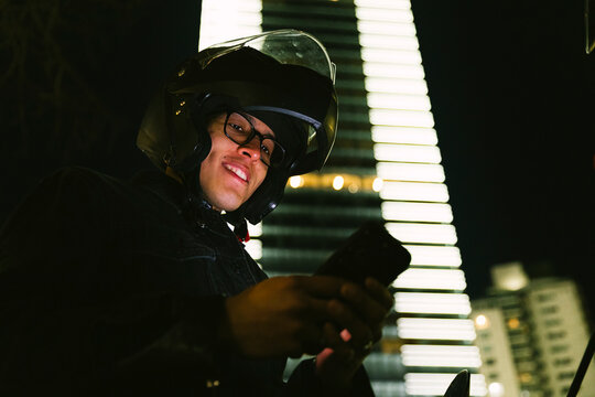 Man in urban setting checking phone at night