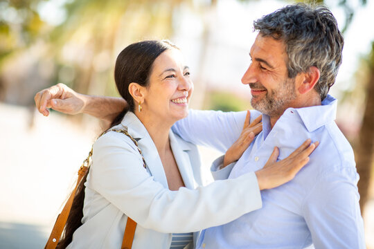 Happy middle-aged couple embracing joyfully outdoors under the sunlight - Powered by Adobe