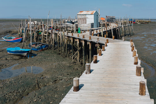 Wooden pier leading to fishing village on dry seabed