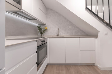 View of a compact kitchen with a 40 cm deep cabinet system, including a single-door refrigerator...