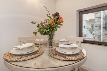 Round dining table in solid oak with four beige upholstered chairs, creating a harmonious and inviting set