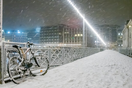 Snowy night on a city bridge with bike