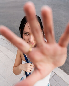 Asian gen z girl with hand gesture in street scene