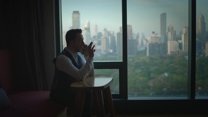 The depiction of a Businessman working in a Contemporary Office in a Modern City Skyline setting