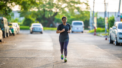 Obraz premium Beautiful asian sport active woman sprint run on city road morning sun light