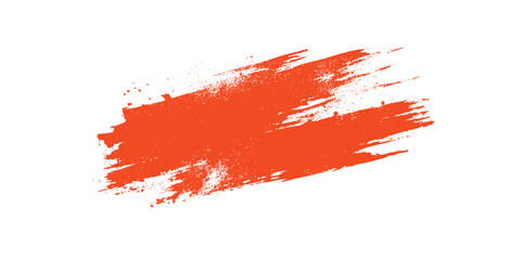 Bright orange textured paint brush stroke with splatters on a white background abstract graphic element