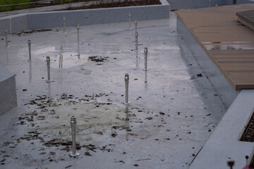 Dry urban fountain with nozzles and seasonal debris