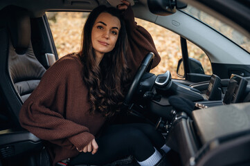 Beautiful woman is sitting in her electric car