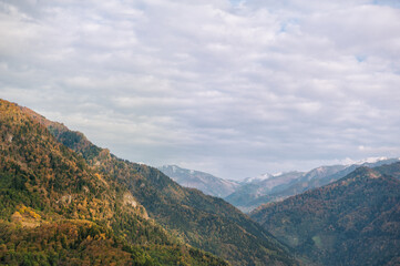 Naklejka premium Mountain valley covered in colorful autumn foliage creates a peaceful scenic landscape