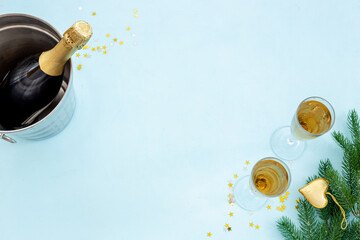 Christmas bottle of champagne with two glasses and fir tree branches, top view. Happy New Year and Merry Christmas decoration