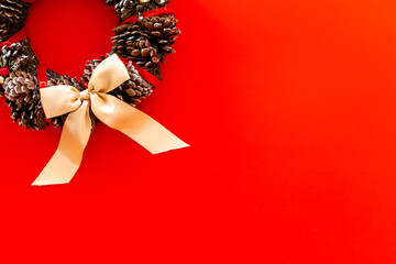 Christmas wreath made of tree bark and dry cones on the wall. New Year DIY decoration