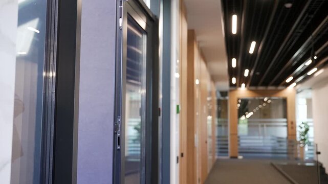 Businessman in a formal suit unlocking door in modern business center using mobile phone application. Scanning open smartphone with mock up screen app. Smart electronic locks with keyless access