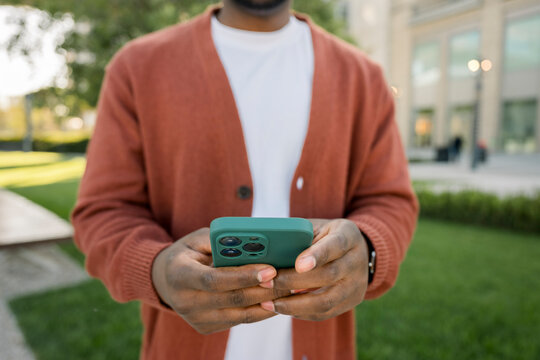 Close up of hands using smartphone outdoors for texting