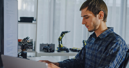 Closeup young adult male freelance developer typing write prompt AI bot app program nomad terminal with coding at office. Artificial intelligence dashboard, robotics, user interface, machine learning.