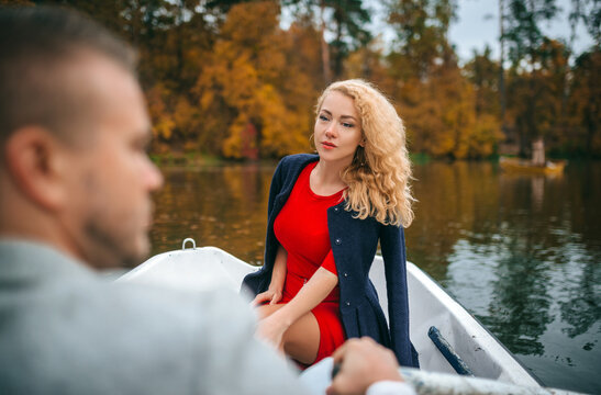 Romantic couple boating on an autumn lake in a park