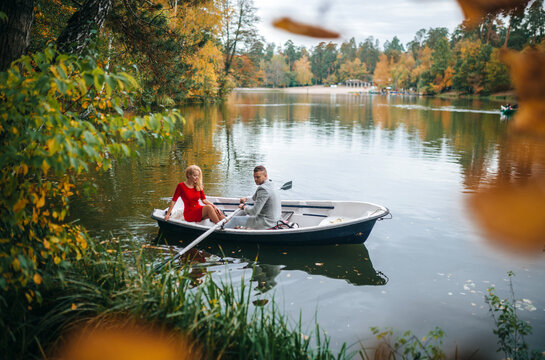 Romantic couple enjoys autumn rowing on peaceful lake