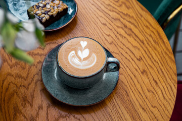 coffee latte art on wood table in cafe outdoor nature light
