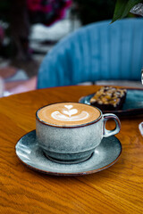 coffee latte art on wood table in cafe outdoor nature light vertical photo