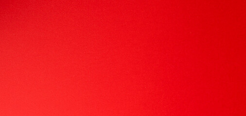 Bold bright red paper with a smooth matte surface creating a clean minimal horizontal backdrop..