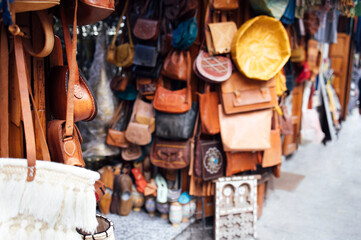 Leather bags and accessories displayed in a vibrant marketplace, showcasing craftsmanship and variety, with textures and colors creating an inviting shopping atmosphere