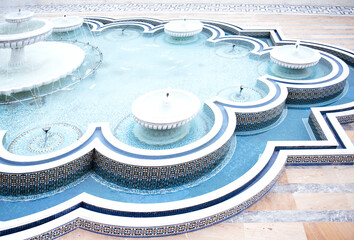 Ornate fountain with intricate tile work and flowing water, surrounded by a beautifully designed pool, creating a serene and tranquil atmosphere for relaxation and reflection