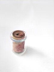 Roll of red Indonesian banknotes on a white background