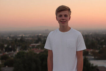 cheerful american teenager is beaming with happiness against backdrop of stunning sunset