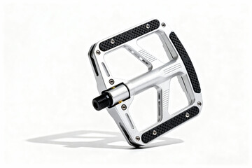 Close up of a silver bicycle pedal with black grips on a white surface casting a soft shadow