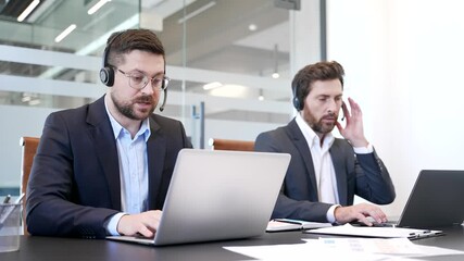 Group of corporate operators working in customer support service on helpline telesale using laptop. Team of call center agents with headsets helping online, speaking and consulting in business office - Powered by Adobe