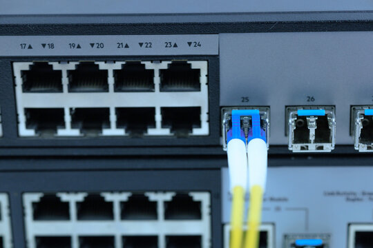 Yellow coiled fiber optic patch cord with blue connectors SFP modules are essential for high-speed data transmission over fiber optic networks.