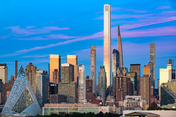 Obraz premium A twilight panorama of the magnificent Midtown Manhattan skyline, seen from across the Hudson River, prominently featuring the colossal towers of Billionaires' Row.