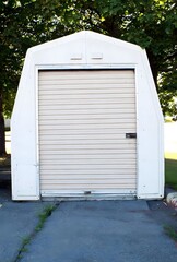 A close-up photograph of a small, white storage shed.