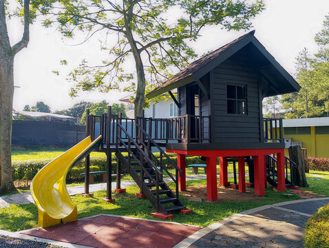 Modern Outdoor Playground with Wooden Playhouse and Bright Yellow Slide