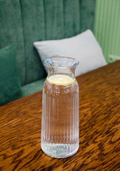 Glass Carafe with Lemon Water on Wooden Table
