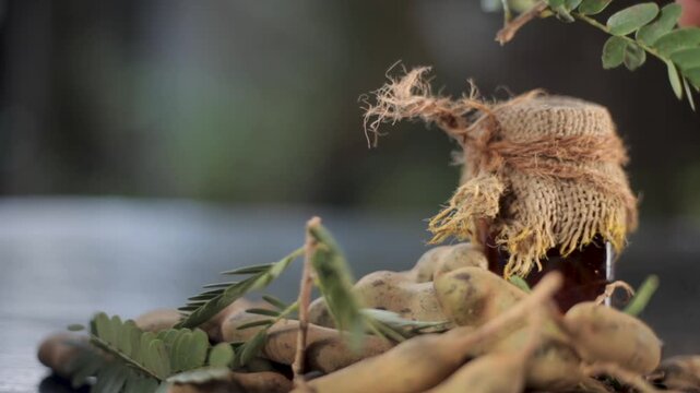 Traditional Ayurvedic Tamarindus indica Extract in Glass Bottle Wrapped with Gunny Cloth and String &ndash; Natural Tamarind Remedy for Skin Care, Acne Spots, Pores and Herbal Beauty Treatment Stock Footage