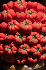Closeup view of festive miniature pumpkins alongside ceramic ornaments with green stems and textured glaze