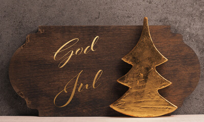 God Jul, Scandinavian Christmas with a rustic golden Christmas tree shape on a wooden background
