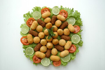 Flat lay of a Brazilian appetizer platter with fried snacks, lettuce, tomato, and lime. Perfect for food blogs, menus, or party planning content.