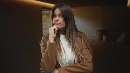 Hispanic woman indoors in a cozy hotel room thinking while wearing casual attire