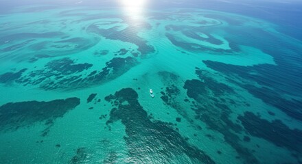 Obraz premium Aerial view captures vibrant turquoise shallow ocean waters revealing underwater formations under bright sunlight