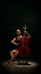 Dancer balancing cello in elegant pose with precision and emotional musical control. Concept of theatre posters, ballet promotion, culture magazines, editorial features, music school visuals. © Lustre Art Group 