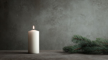 white candle elegantly placed against backdrop of grey concrete and pine branch exuding calm