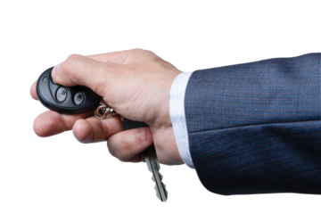 Hand holding remote key fob with keys in suit while preparing to unlock car door