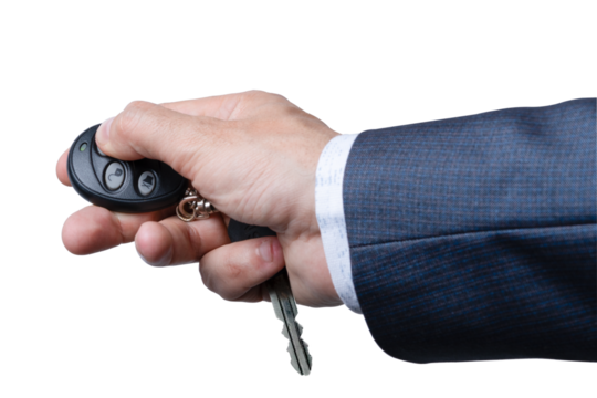 Hand holding remote key fob with keys in suit while preparing to unlock car door