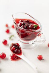 Homemade cranberry sauce in glass bowl. Fresh berry and thyme